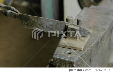 Making the knife out of metal at the forge. Alignment of the knife blades after hardening of the 47679507