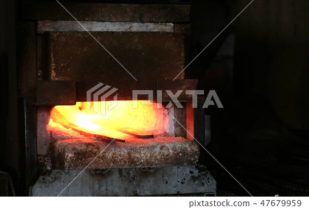 Making the sword out of metal at the forge. Heating of metal billets in the furnace. 47679959