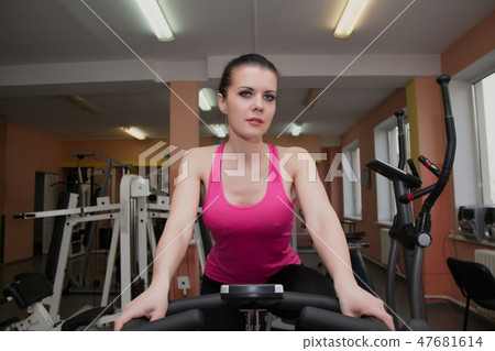 Beautiful girl exercising in a fitness club on a 47681614