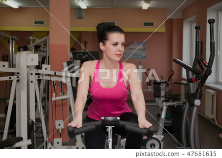 Beautiful girl exercising in a fitness club on a 47681615