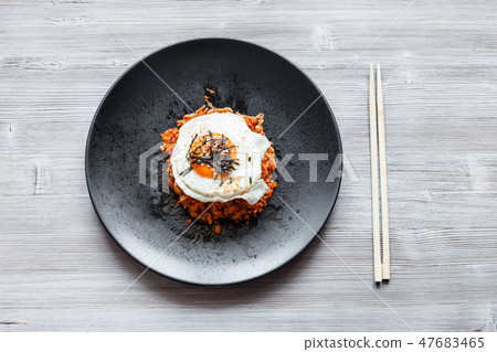 Kimchi bokkeum bap on black plate and chopsticks Kimchi bokkeum bap on black plate and chopsticks 47683465