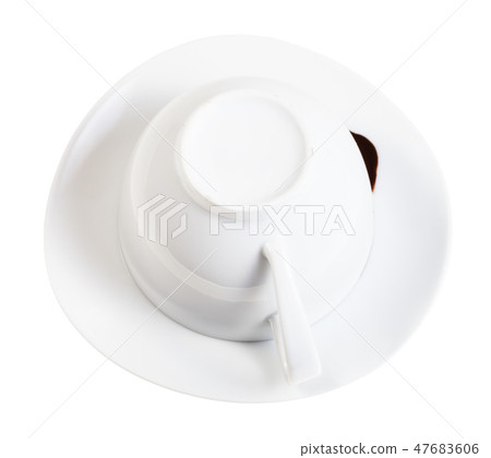 flipped cup with carob grounds on saucer isolated 47683606