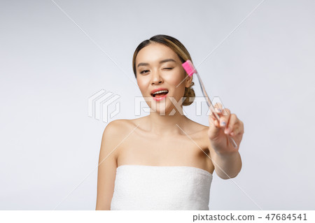 Beautiful young woman on white isolated background holds a toothbrush, Asian Beautiful young woman on white isolated background holds a toothbrush, Asian 47684541