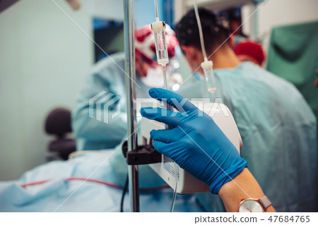 Nurse sets the patient's dropper on the background operation 47684765