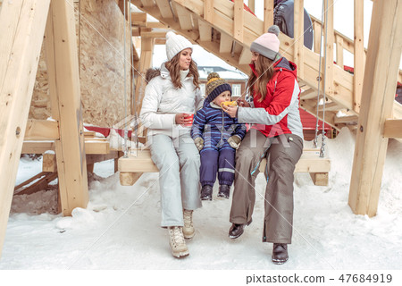 Two girls women swing on wooden swing, child little boy 2-3 years old. Happy rest on holiday. In Two girls women swing on wooden swing, child little boy 2-3 years old. Happy rest on holiday. In 47684919