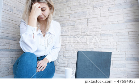 Woman looks at her laptop with a pained worried expression 47684955