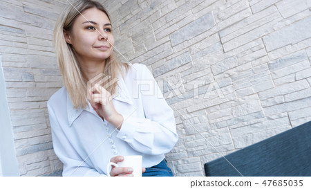 Side view. Young business woman with a cup of coffee and notebook. Side view. Young business woman with a cup of coffee and notebook. 47685035