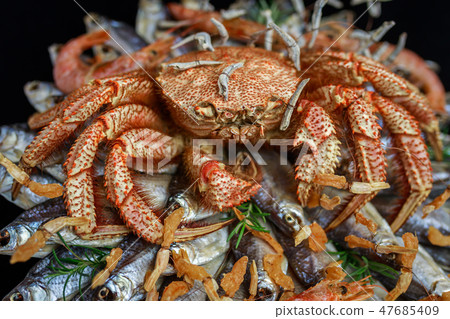 Big hairy boiled crab sits on a heap of fish 47685409