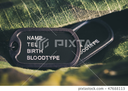 Soldier tag or dog tag laid on military jacket. 47688113
