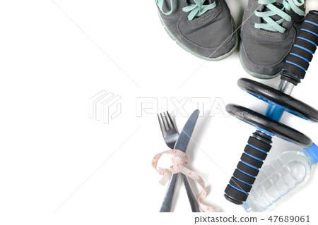 Sneakers and fitness wheel on white background 47689061