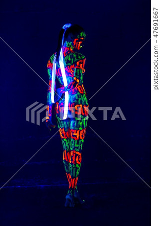 Woman with UV bodyart full-length rearview 47691667