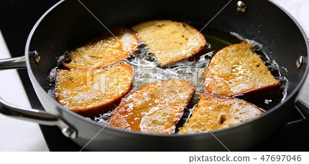 Frying bread in hot oil 47697046