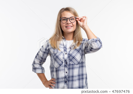 Teeth health, dentistry and bite correction - Happy smiling woman in glasses with braces on white Teeth health, dentistry and bite correction - Happy smiling woman in glasses with braces on white 47697476