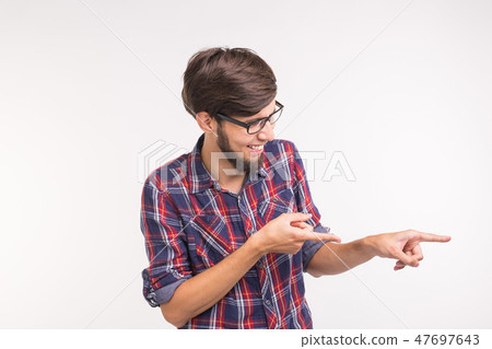 Expression and gesture concept - young man pointing a side over white background 47697643