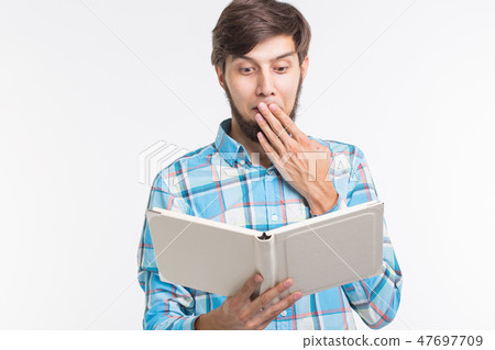 Education, leisure and people concept - young beard man reading a book and surprised 47697709
