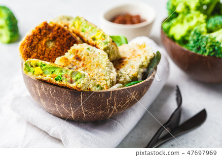 Green broccoli burgers in coconut shell dish Green broccoli burgers in coconut shell dish 47697969
