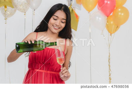 Attractive woman pouring champagne at party. Attractive woman pouring champagne at party. 47698036
