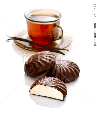 A chocolate-coated zefir with tea. A chocolate-coated zefir with tea. 47698741