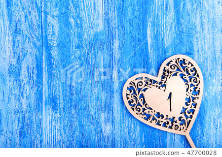 ooden heart carved on a blue wooden background 47700028