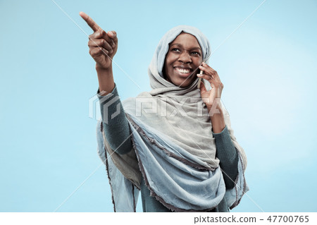 The beautiful young black muslim girl wearing gray hijab, with a happy smile on her face. The beautiful young black muslim girl wearing gray hijab, with a happy smile on her face. 47700765