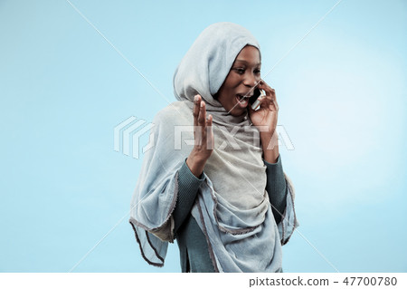 The beautiful young black muslim girl wearing gray hijab, with a happy smile on her face. The beautiful young black muslim girl wearing gray hijab, with a happy smile on her face. 47700780