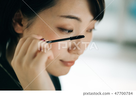 一位年輕日本婦女繪畫染睫毛油 47700784