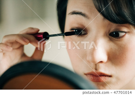 Young Japanese lady painting mascara Young Japanese lady painting mascara 47701014