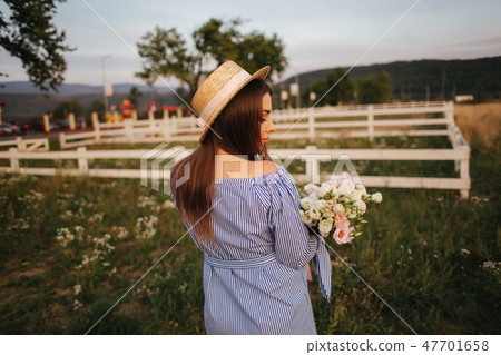Back view of pregnant woman. She hold a bouquet of flowers and smile Back view of pregnant woman. She hold a bouquet of flowers and smile 47701658
