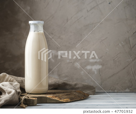 Fresh milk in glass bottle on rustic background Fresh milk in glass bottle on rustic background 47701932