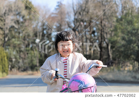 A girl riding a bicycle A girl riding a bicycle 47702002