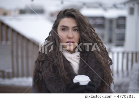 girl in a coat with coffee 47702813