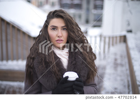 girl in a coat with coffee girl in a coat with coffee 47702814