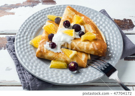 A portion of pancakes with berries and cream A portion of pancakes with berries and cream 47704172