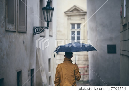 Lonely man with umbrella in rain Lonely man with umbrella in rain 47704524
