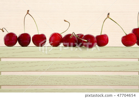 Ripe red sweet cherry on a plywood shelf Ripe red sweet cherry on a plywood shelf 47704654