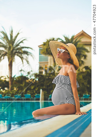 Beautiful pregnant woman in swimming pool 47704923