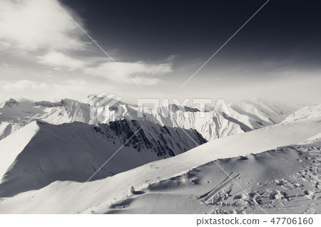 Black and white snowy mountains at sunny evening 47706160