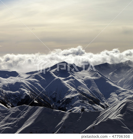 Snowy mountains and sky with sunlight clouds Snowy mountains and sky with sunlight clouds 47706308