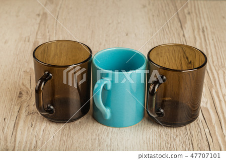 Three cups on a wooden background in different 47707101