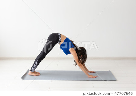 Healthy lifestyle, people and sport concept - Young woman with curly hair doing yoga over white 47707646