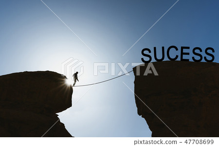 a man balancing walking on rope to success 47708699