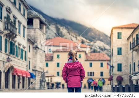 Girl in a waterproof jacket in Kotor Old Town Girl in a waterproof jacket in Kotor Old Town 47710733