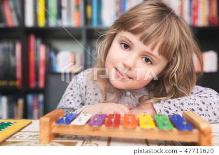 Cute little girl playing colorful cymbals 47711620