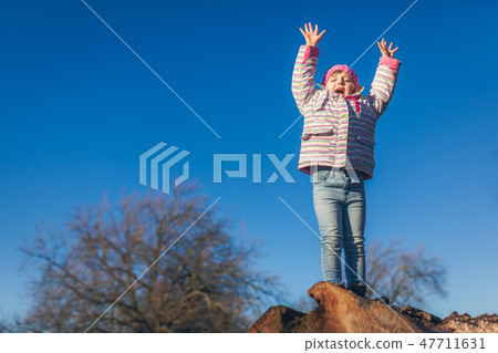 Happy girl on a large tree log Happy girl on a large tree log 47711631
