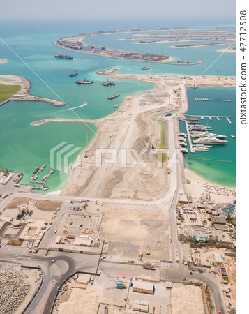 Construction of an artificial island Palm Jumeirah with construction equipment in Dubai. Construction of an artificial island Palm Jumeirah with construction equipment in Dubai. 47712508