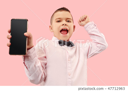 Indoor portrait of attractive young boy holding blank smartphone Indoor portrait of attractive young boy holding blank smartphone 47712963