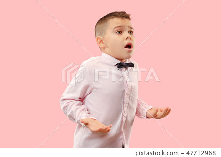 The young attractive teen boy looking suprised isolated on pink 47712968
