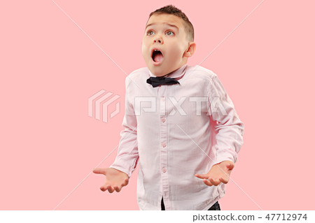 The young attractive teen boy looking suprised isolated on pink The young attractive teen boy looking suprised isolated on pink 47712974