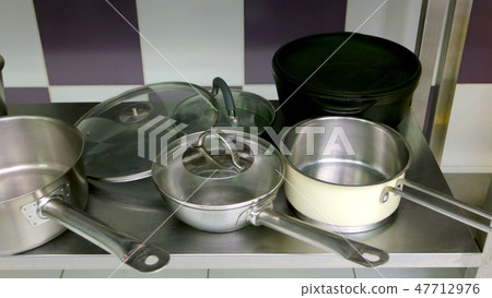 Stainless steel pans in the kitchen table. Stainless steel pans in the kitchen table. 47712976