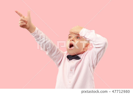 The young attractive teen boy looking suprised isolated on pink The young attractive teen boy looking suprised isolated on pink 47712980